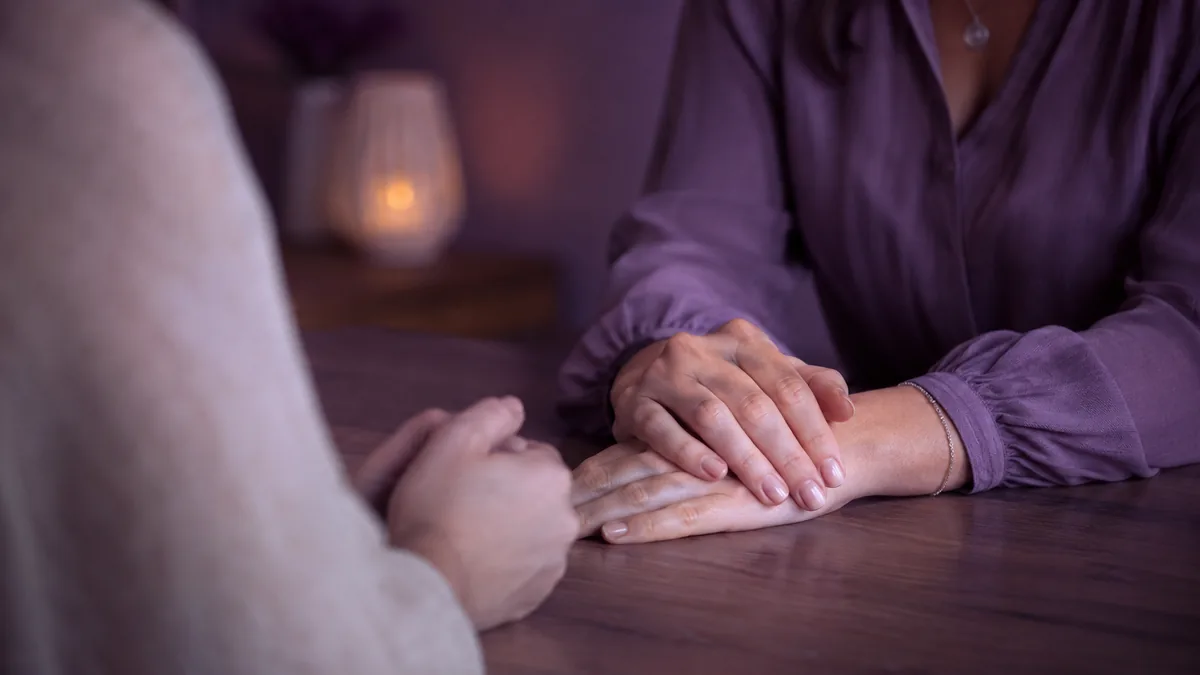 Two people in a calm, respectful conversation across a desk