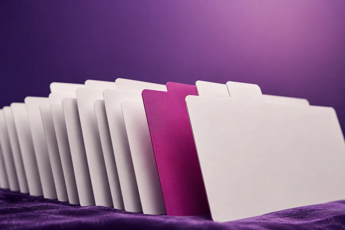 Neatly organized clinical note cards fanned in sequence, one magenta accent